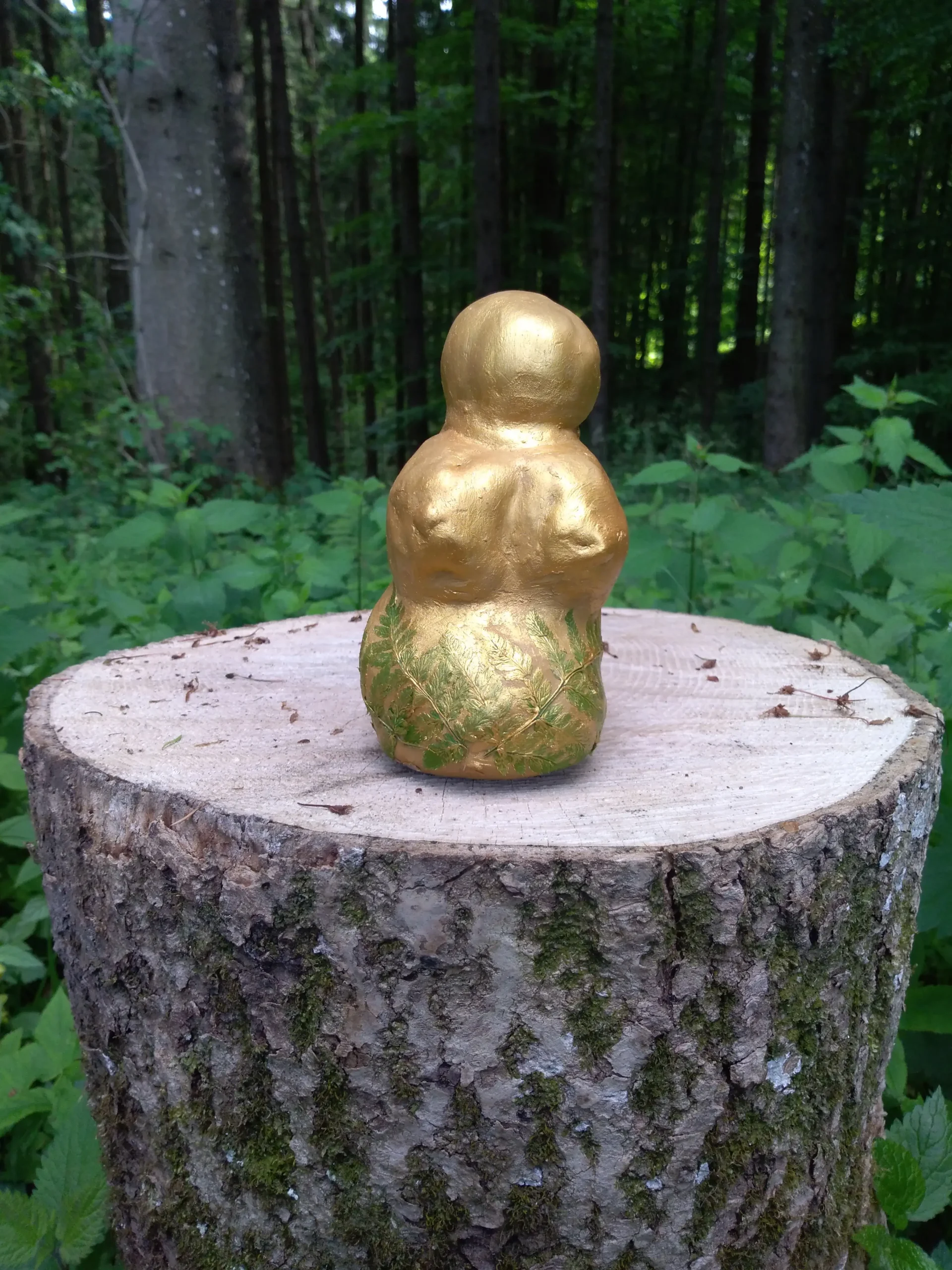 Venus-Statue auf einem Holzstock im Wald